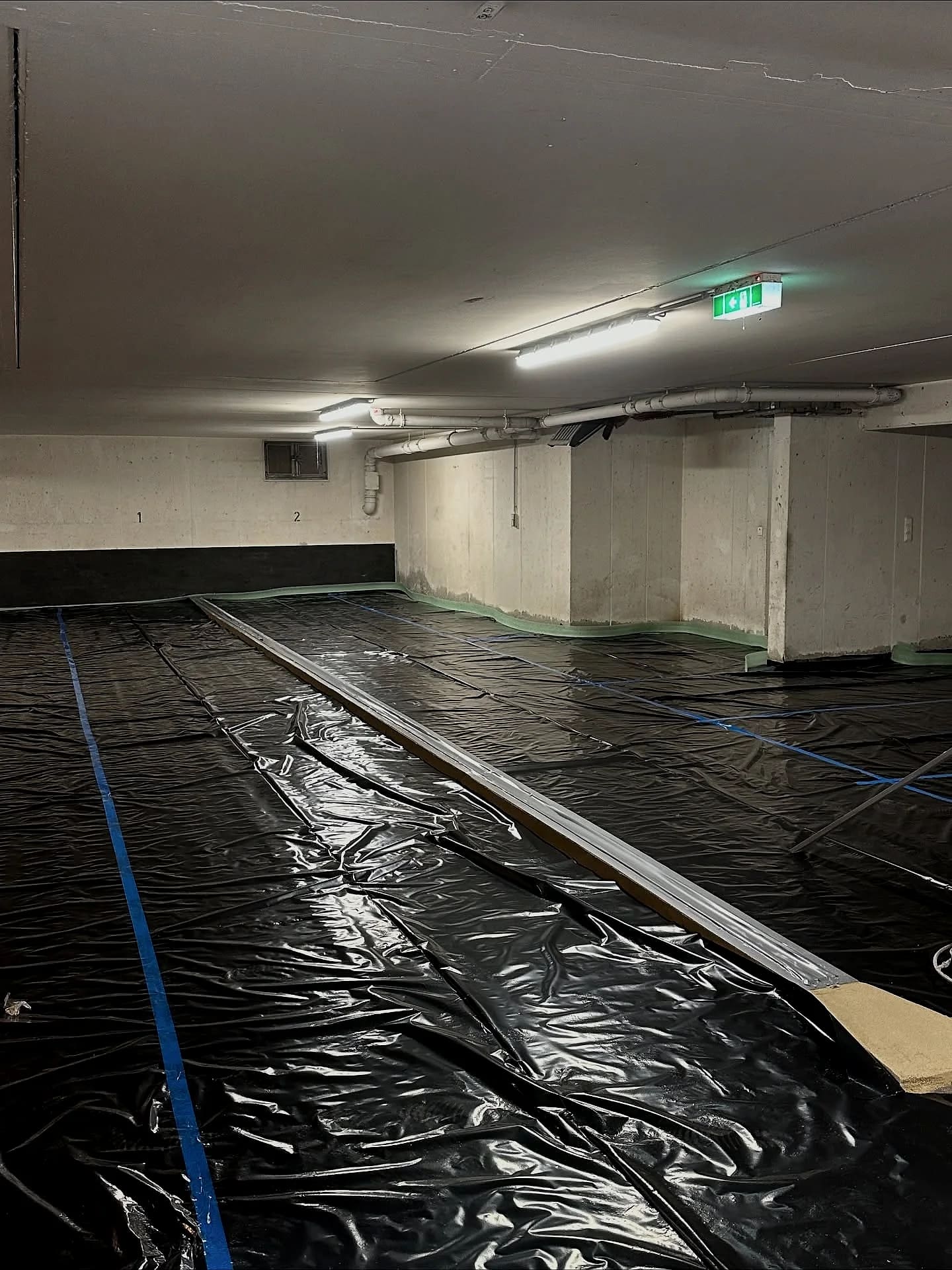 Ausgelegte Folie mit gesetzten Lehren in der Tiefgarage