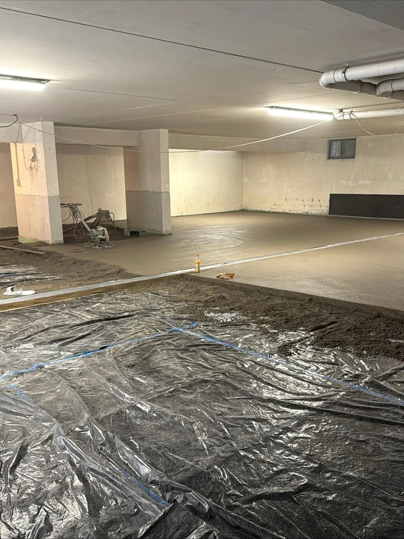 Halb eingebaute Estrichfläche in der Tiefgarage, dahinter der Flügelglätter